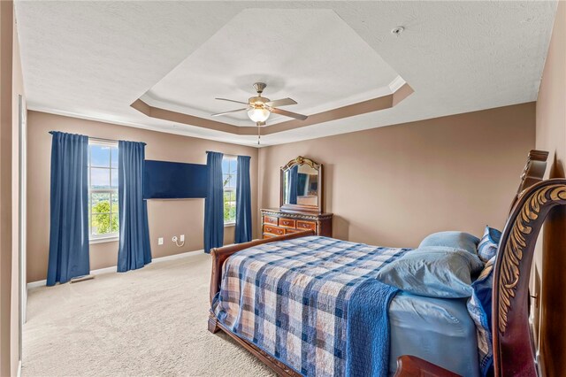 carpeted bedroom featuring ceiling fan, a textured ceiling, and a tray ceiling