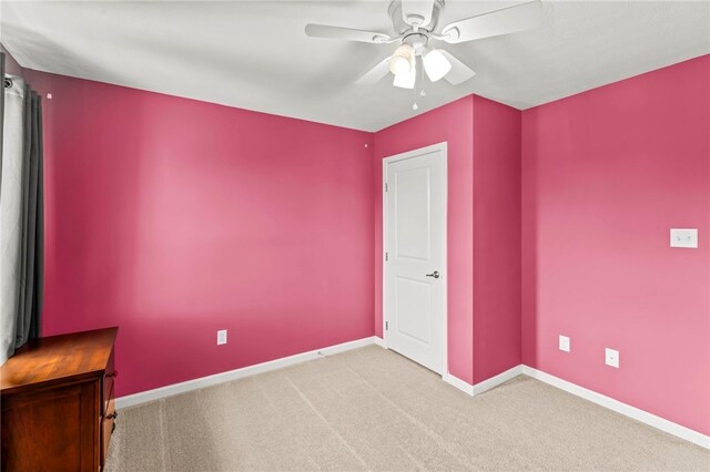 spare room featuring ceiling fan and light colored carpet