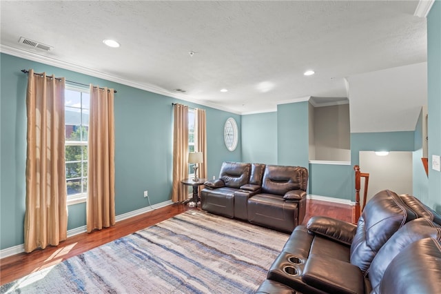 living room with hardwood / wood-style floors, crown molding, and a textured ceiling