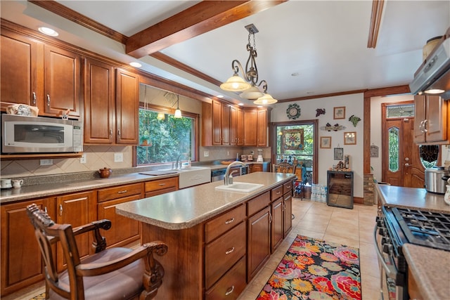 kitchen with appliances with stainless steel finishes, light tile patterned flooring, plenty of natural light, and decorative light fixtures