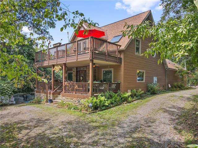 back of property featuring roof with shingles, ceiling fan, and a wooden deck