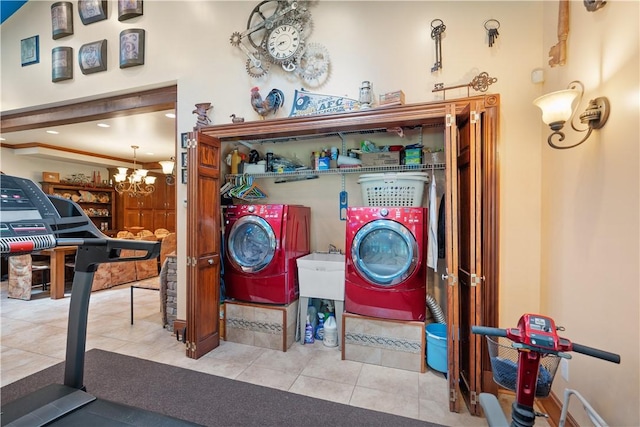 washroom with washing machine and dryer, tile patterned floors, and a chandelier