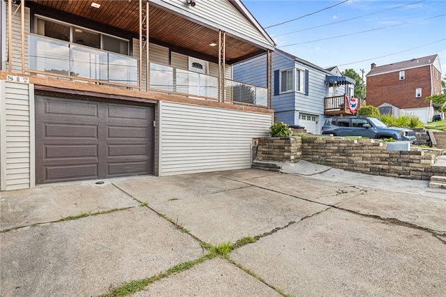 view of property exterior featuring a balcony and a garage