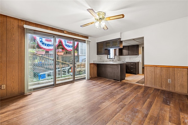 unfurnished living room featuring sink, hardwood / wood-style floors, and ceiling fan