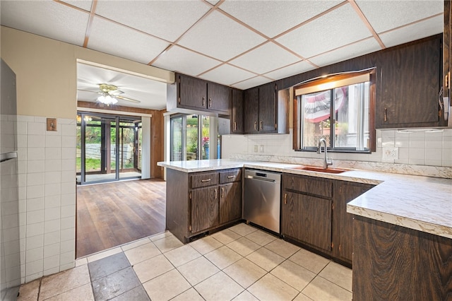 kitchen featuring stainless steel dishwasher, light hardwood / wood-style floors, backsplash, ceiling fan, and sink