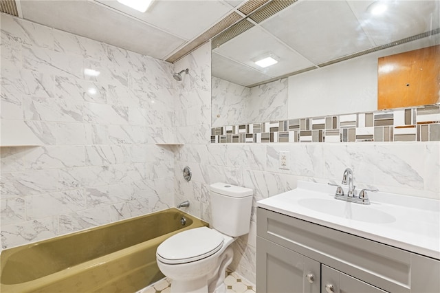 full bathroom featuring tile walls, toilet, vanity, and tiled shower / bath