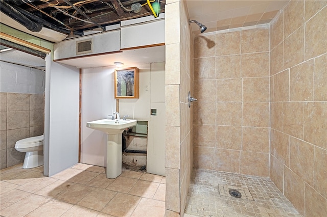 bathroom with toilet, tile walls, sink, tile patterned flooring, and walk in shower