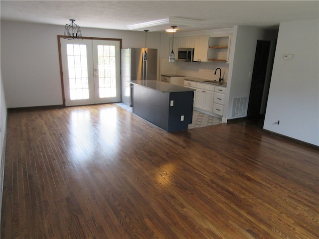 unfurnished living room featuring french doors, dark wood-type flooring, and sink