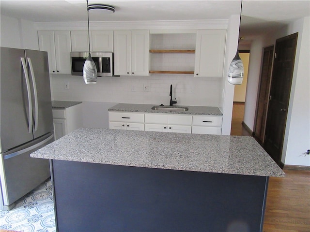 kitchen featuring wood-type flooring, light stone countertops, stainless steel appliances, and white cabinetry