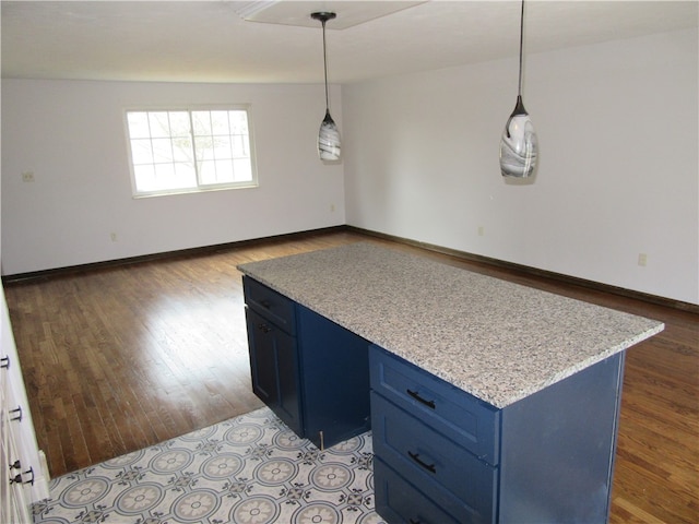 kitchen featuring blue cabinets, pendant lighting, a center island, and hardwood / wood-style floors