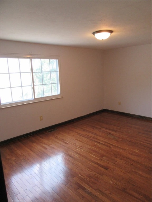 empty room with hardwood / wood-style flooring