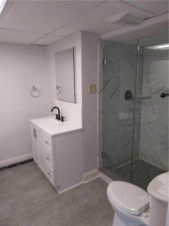 bathroom with toilet, a paneled ceiling, an enclosed shower, tile patterned flooring, and vanity