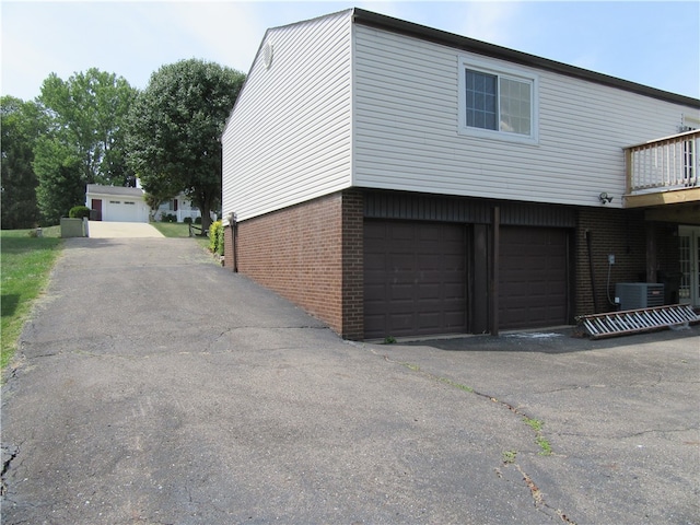 view of property exterior with a garage and cooling unit