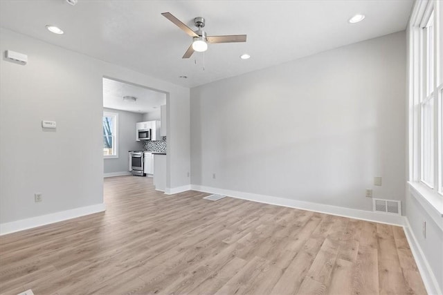 unfurnished living room with baseboards, visible vents, ceiling fan, and light wood finished floors