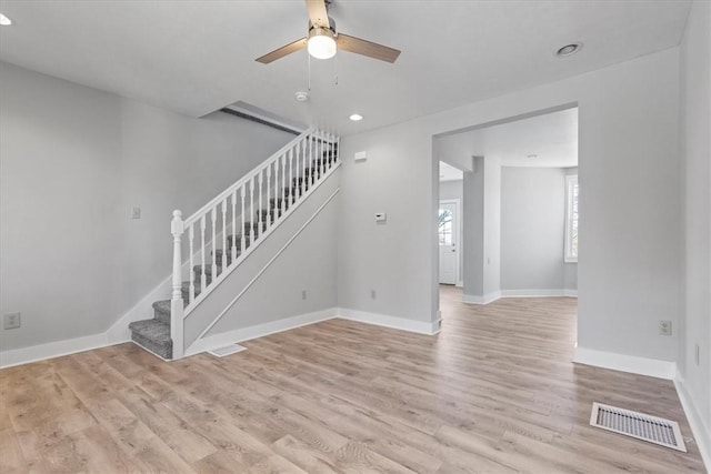 interior space featuring stairway, baseboards, visible vents, and light wood-style floors