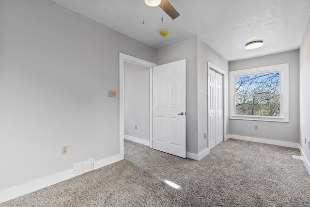 unfurnished bedroom with carpet floors, a closet, visible vents, and baseboards