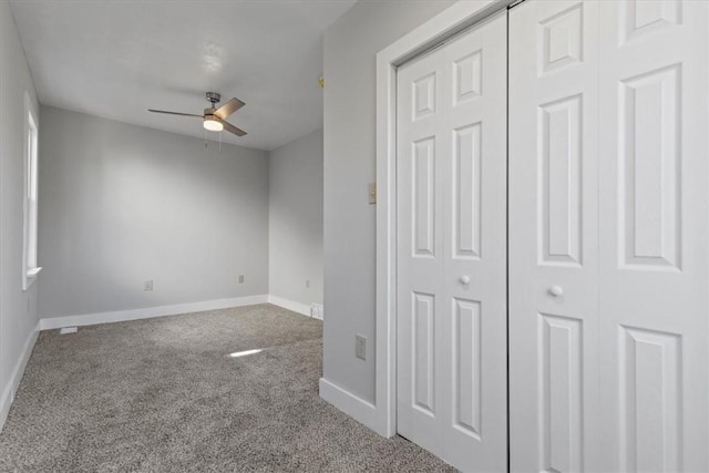 unfurnished bedroom featuring carpet, a closet, baseboards, and a ceiling fan