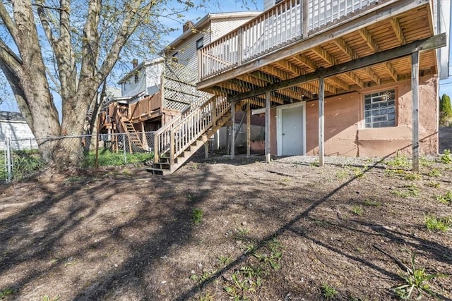 rear view of house with stairs, a deck, and fence