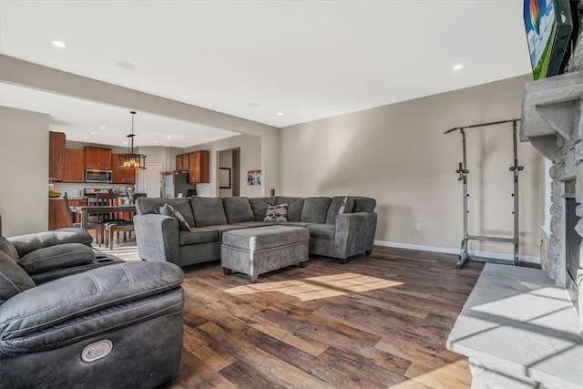 living room with a fireplace, a chandelier, and hardwood / wood-style floors