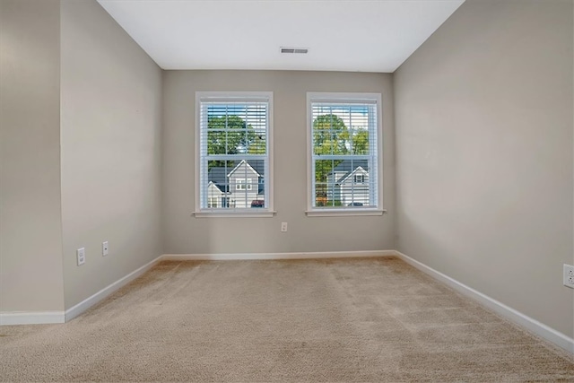 unfurnished room featuring light carpet