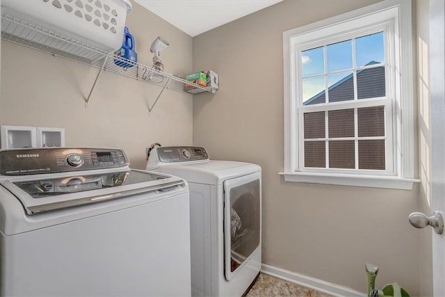 clothes washing area featuring light tile patterned floors and washing machine and dryer