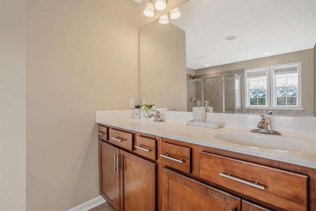 bathroom with dual vanity and an enclosed shower