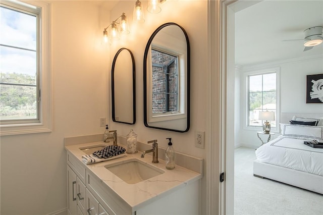 bathroom with double vanity, a sink, a ceiling fan, and baseboards