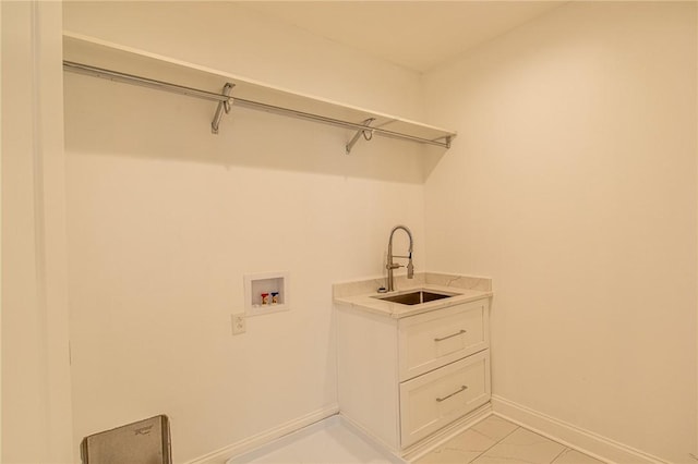 clothes washing area featuring washer hookup, laundry area, a sink, and baseboards