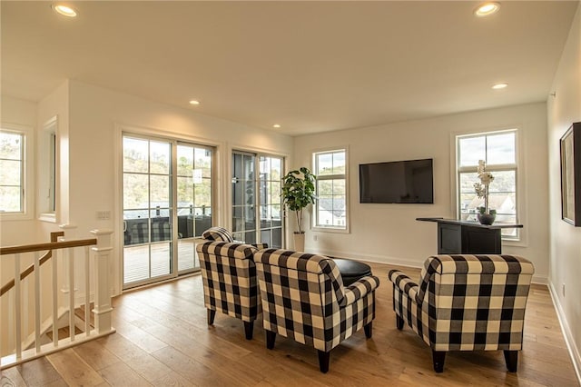 living room featuring wood-type flooring, baseboards, and recessed lighting