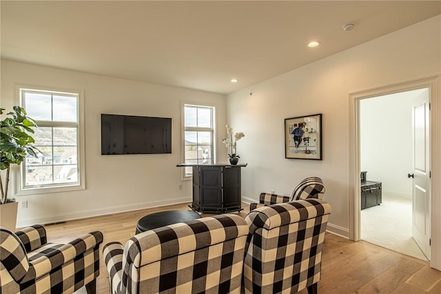 living area with baseboards, light wood-style flooring, and recessed lighting