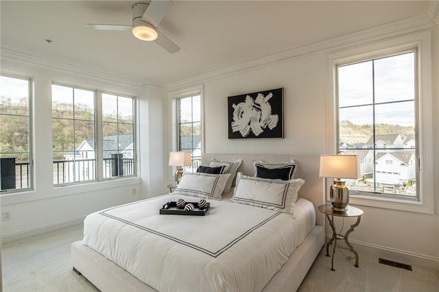 bedroom featuring carpet floors, a ceiling fan, baseboards, visible vents, and crown molding