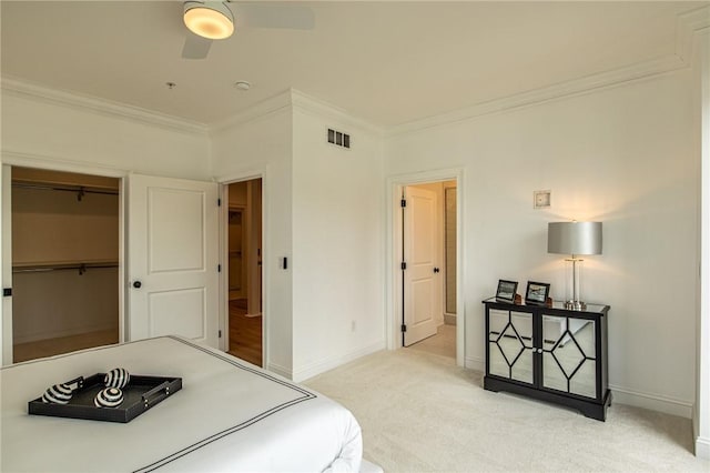 bedroom with light carpet, crown molding, visible vents, and baseboards