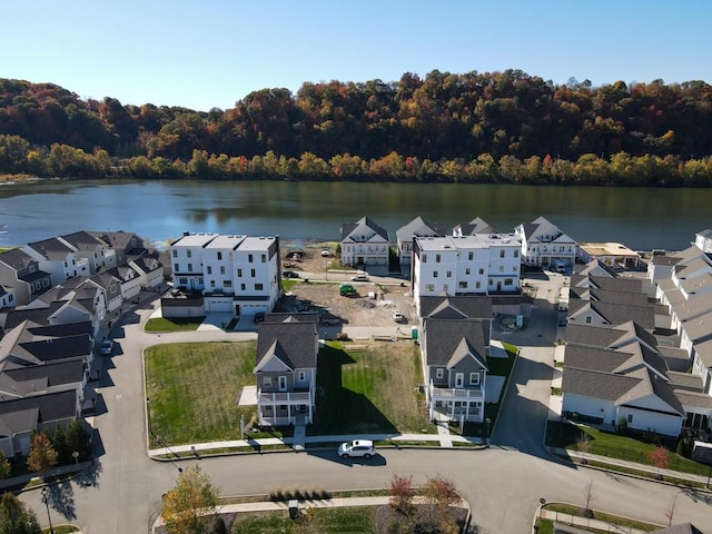 drone / aerial view with a water view, a wooded view, and a residential view