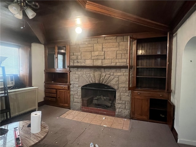 unfurnished living room featuring light carpet, ceiling fan, radiator, a fireplace, and beamed ceiling