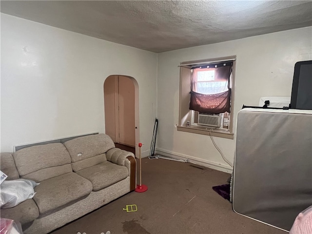 living room featuring cooling unit and a textured ceiling