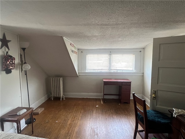 bonus room featuring hardwood / wood-style flooring, a textured ceiling, and radiator heating unit