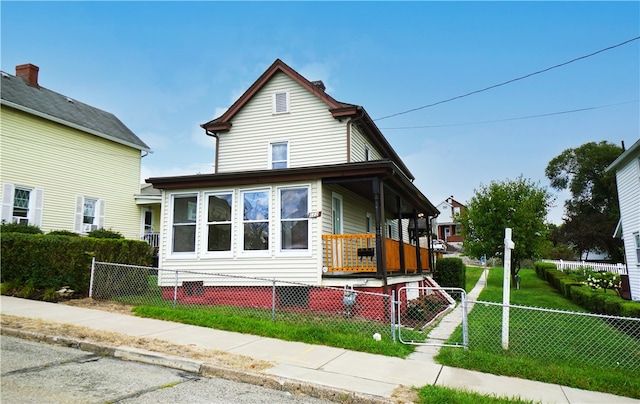 view of front of property with a fenced front yard, a porch, and a front lawn