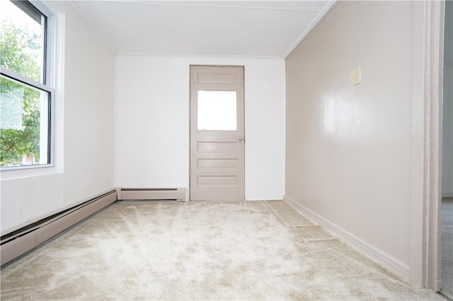 empty room with light colored carpet, baseboard heating, and crown molding