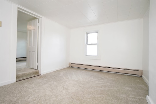 spare room featuring light colored carpet, crown molding, and a baseboard heating unit