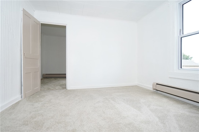 carpeted spare room featuring ornamental molding and a baseboard heating unit