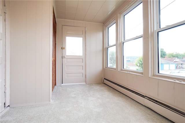 spare room featuring light carpet and a baseboard heating unit