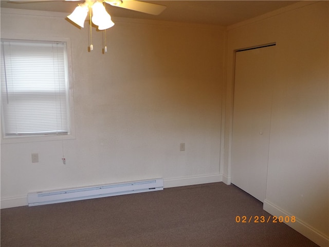 spare room with dark carpet, a baseboard radiator, and ceiling fan