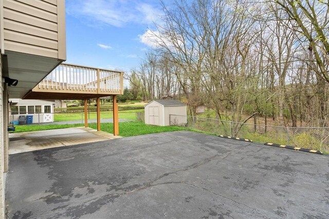 view of patio with a deck and a storage shed