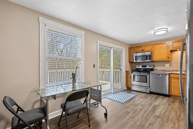 kitchen featuring light hardwood / wood-style flooring, appliances with stainless steel finishes, and a textured ceiling