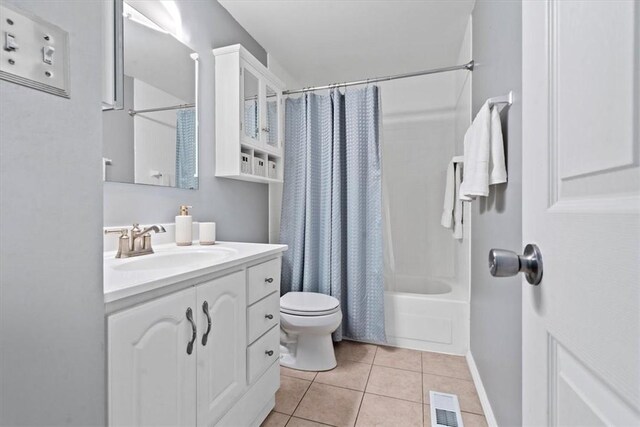 full bathroom featuring toilet, shower / bath combination with curtain, tile patterned floors, and vanity