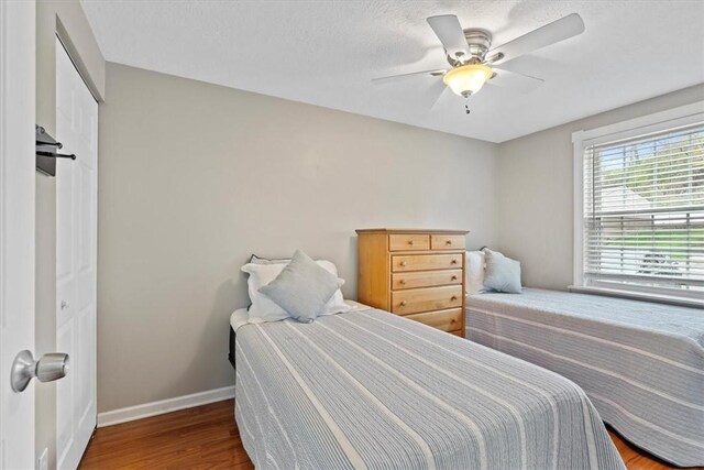 bedroom featuring ceiling fan, a closet, and hardwood / wood-style flooring