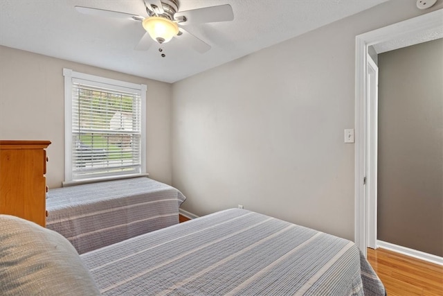 bedroom with ceiling fan and wood-type flooring