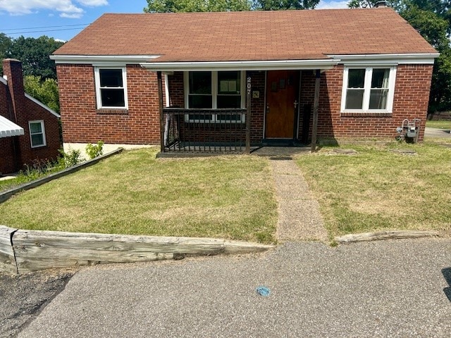 bungalow with covered porch and a front yard