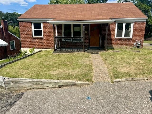 bungalow-style home with a front yard and covered porch