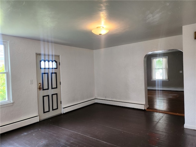 interior space with a baseboard radiator, dark hardwood / wood-style flooring, and a wealth of natural light